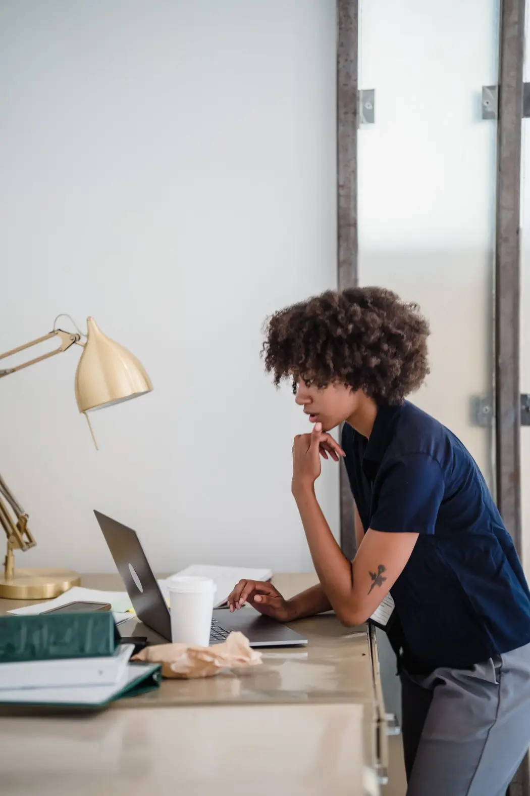 A woman studying on her laptop at a desk